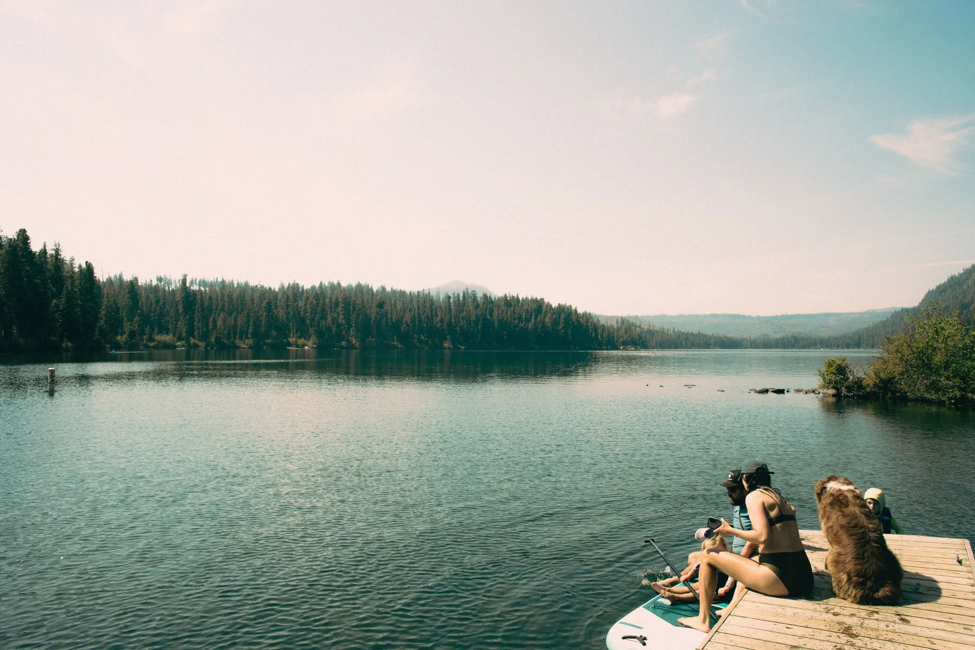 Moment by a stunning lake in Bend, Oregon, with friends and a dog enjoying
