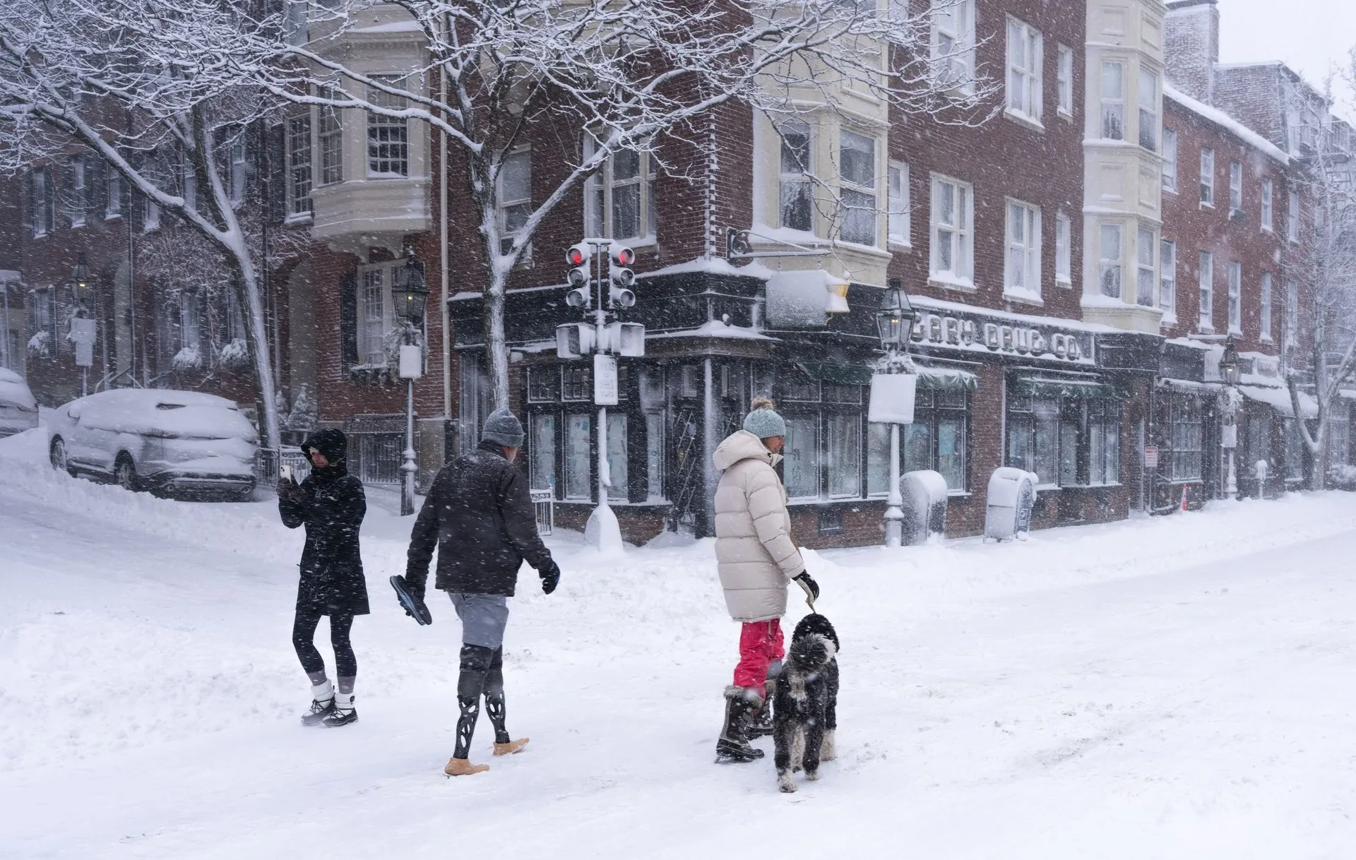 Snowy day in Boston with people and dog walking through historic streets