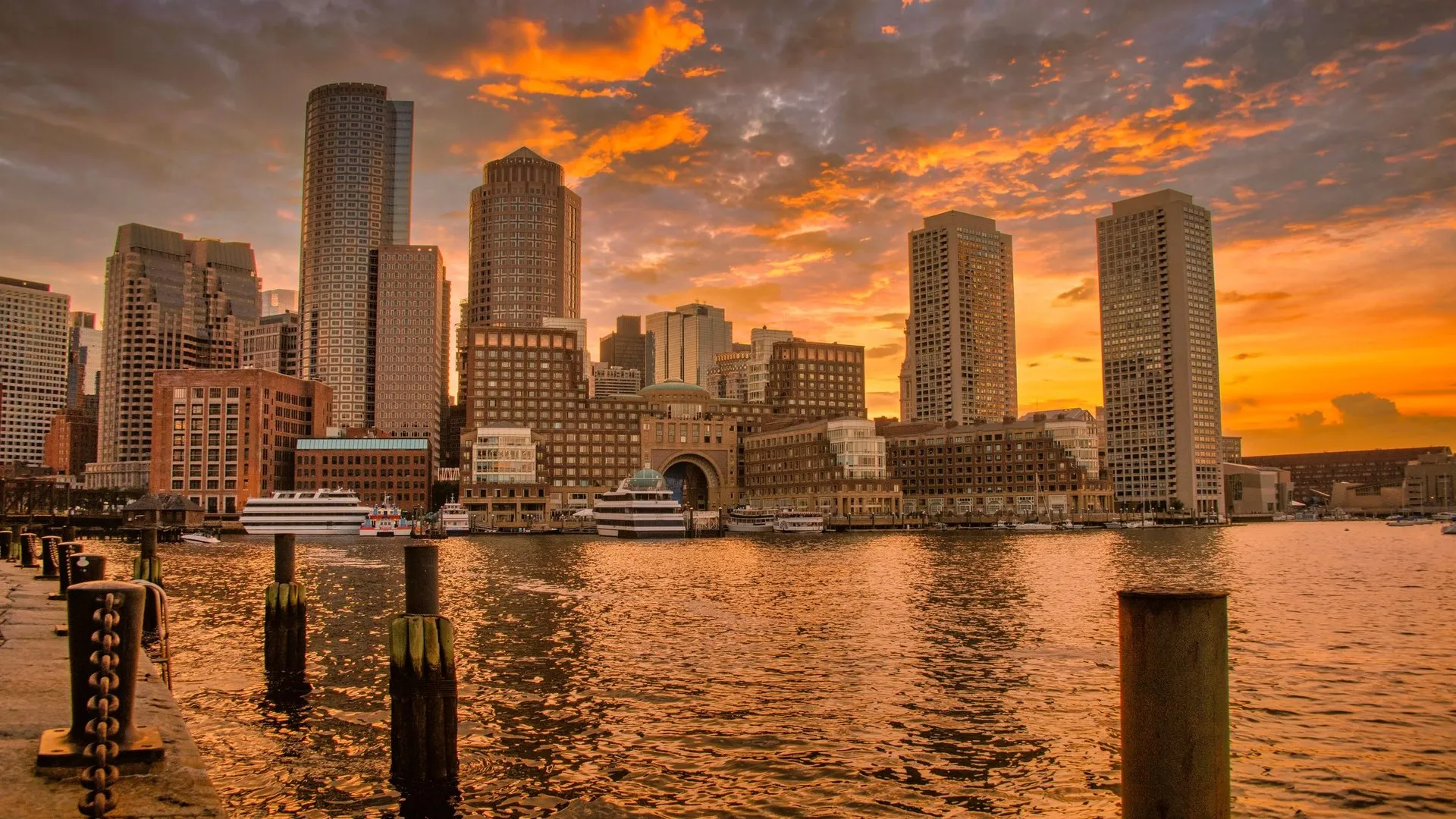 Sunset over Boston's iconic skyline reflecting in the harbor waters