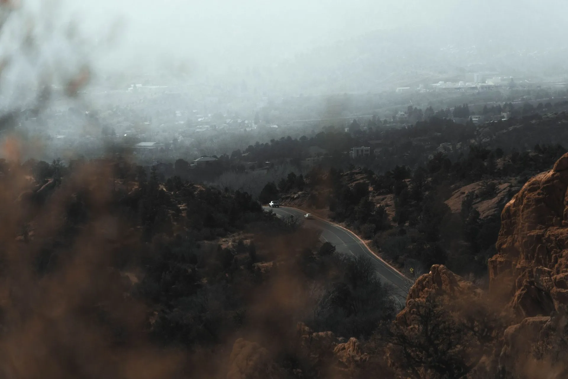 Aerial view of a winding mountain road through misty landscapes in
