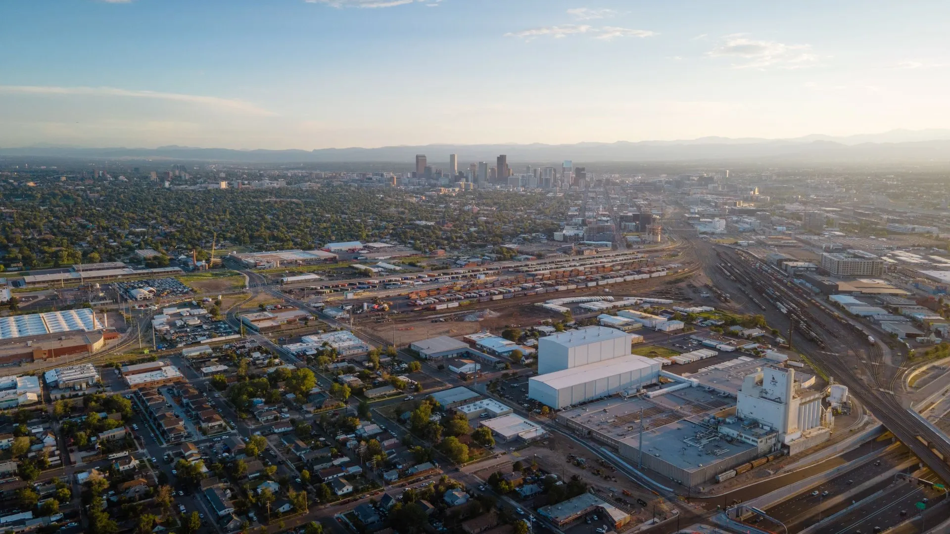 Aerial view of Denver cityscape with urban sprawl and distant skyline