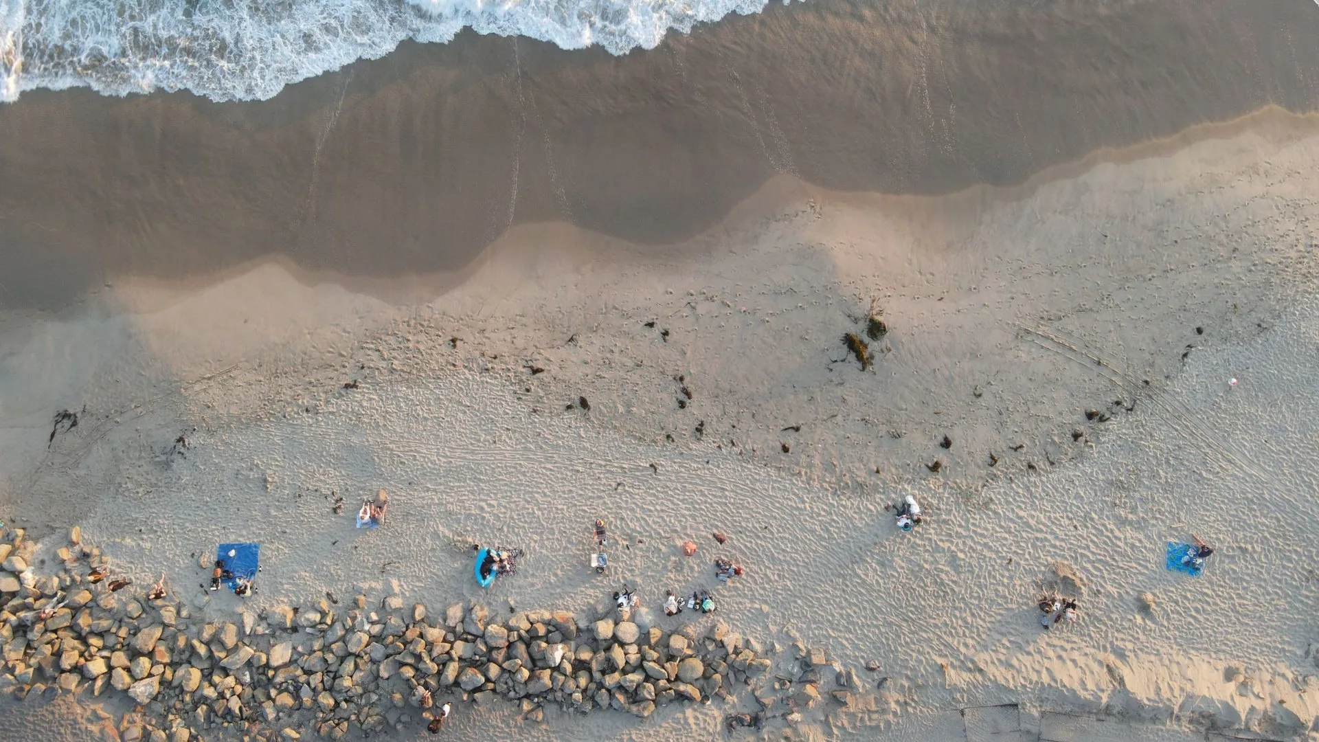 Drone shot of people relaxing on Huntington Beach, California's sandy coast