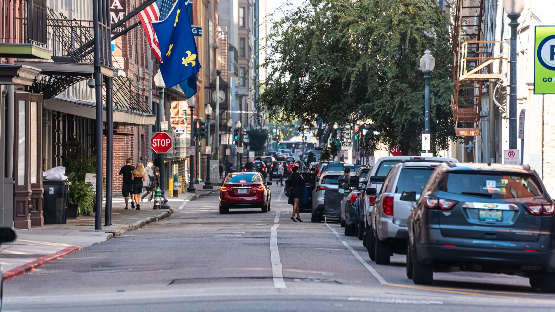 Bustling street in New Orleans with cars, pedestrians