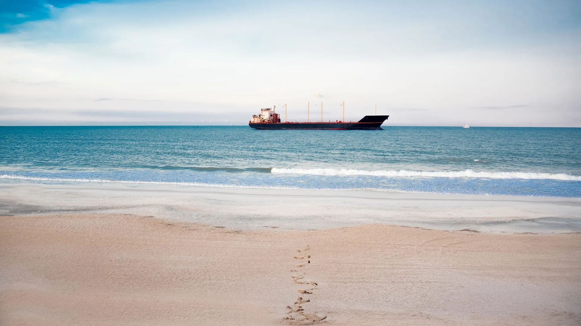 Beach scene with a cargo ship in St. Augustine, Florida