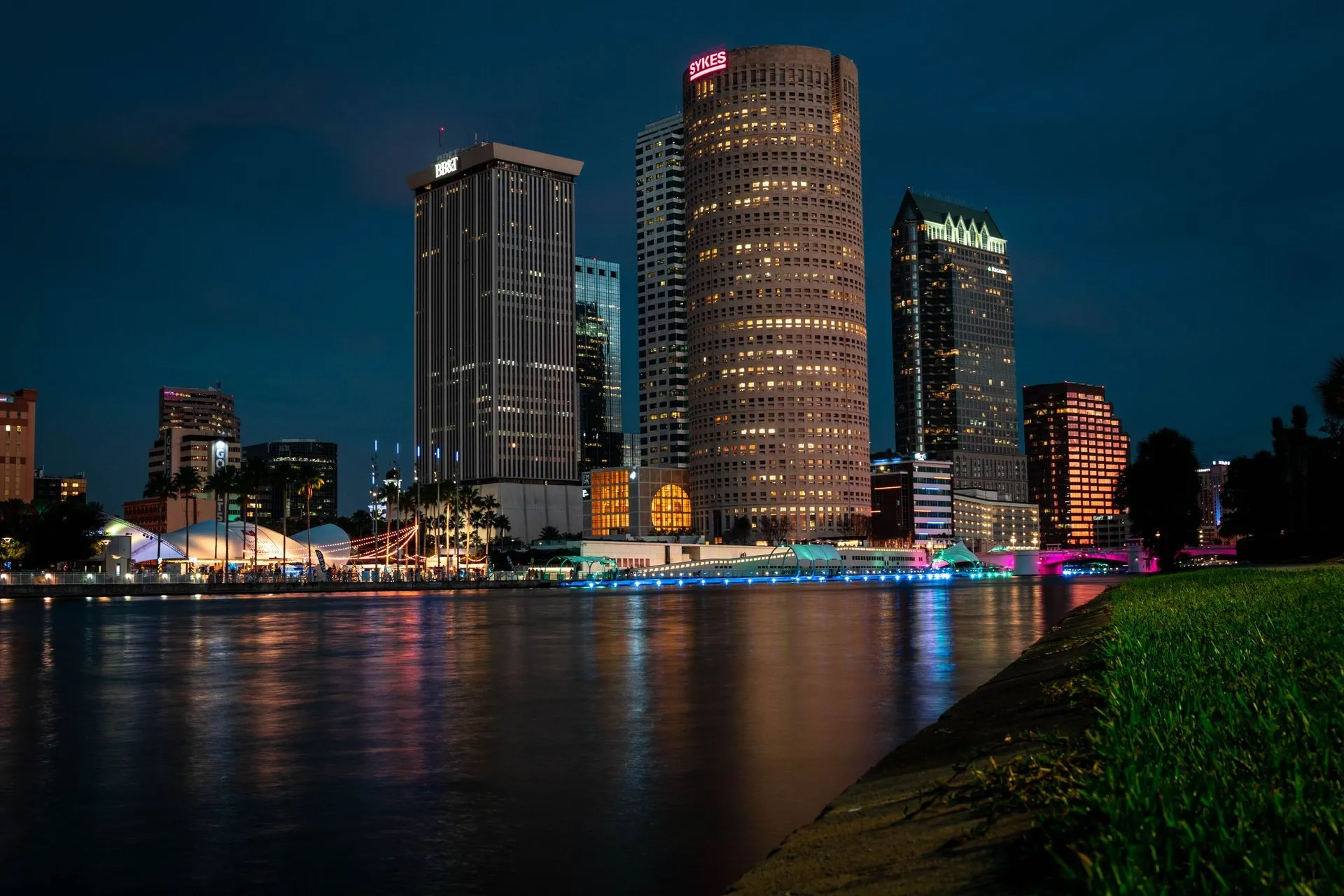 Explore Tampa's stunning evening skyline reflected on the calm river
